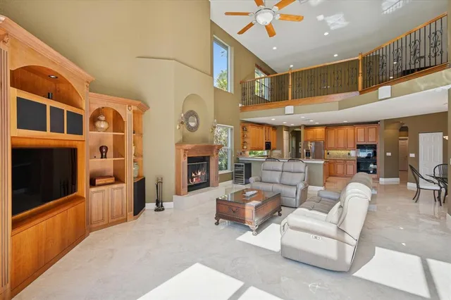 a living room with fireplace furniture and a view of kitchen
