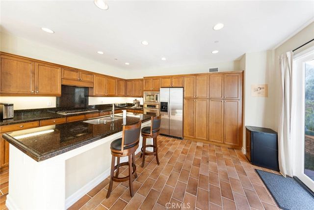 a kitchen with a sink a counter top space stainless steel appliances and cabinets