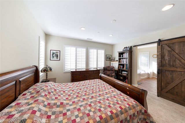 a large bedroom with a bed and wooden floor