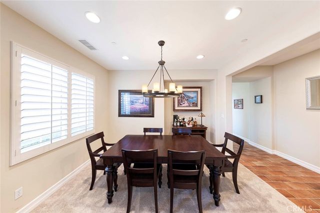 a dining room with furniture a chandelier and window