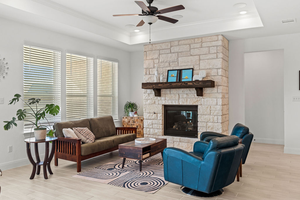 279 Fish Trap Road Dripping Springs, TX 78620 - Photo 10 of 36 Cozy up by this limestone-to-ceiling fireplace upgrade. Turns on with a switch!