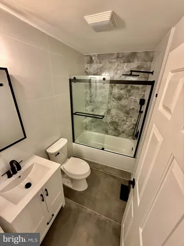 a bathroom with a sink mirror vanity and toilet