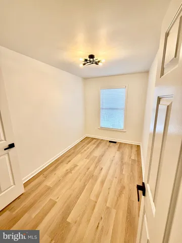 a view of a room with wooden floor and a ceiling fan