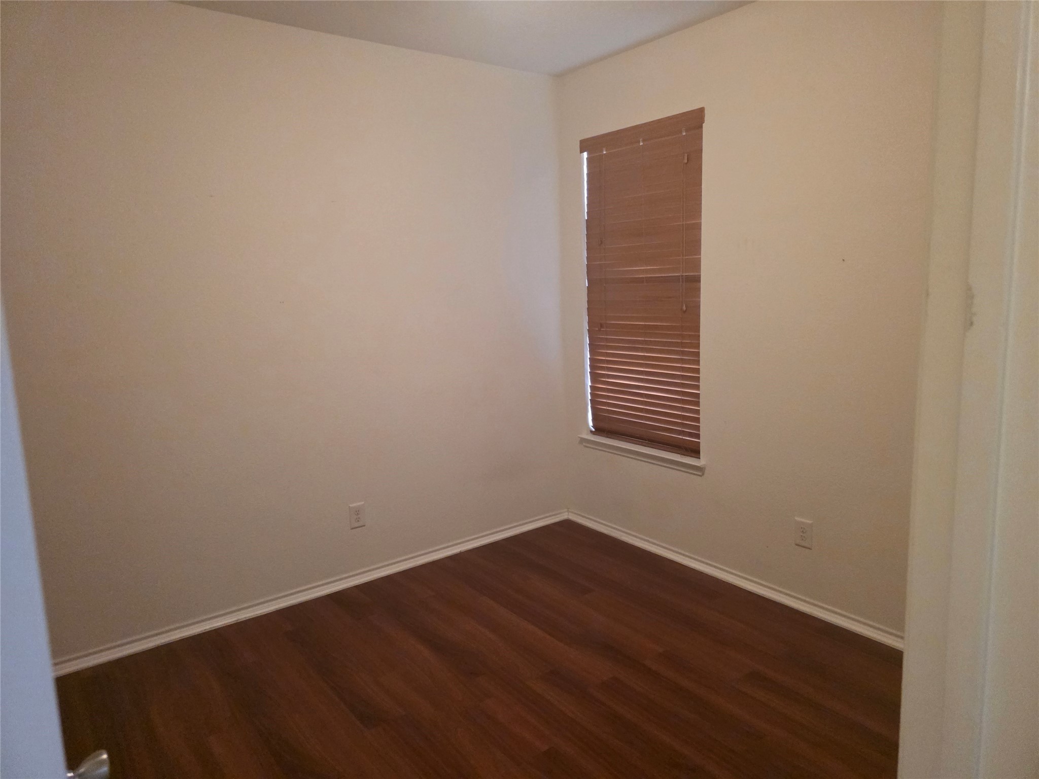 12062 Bach Orchard Trail Houston, TX 77038 - Photo 14 of 20 an empty room with wooden floor and windows
