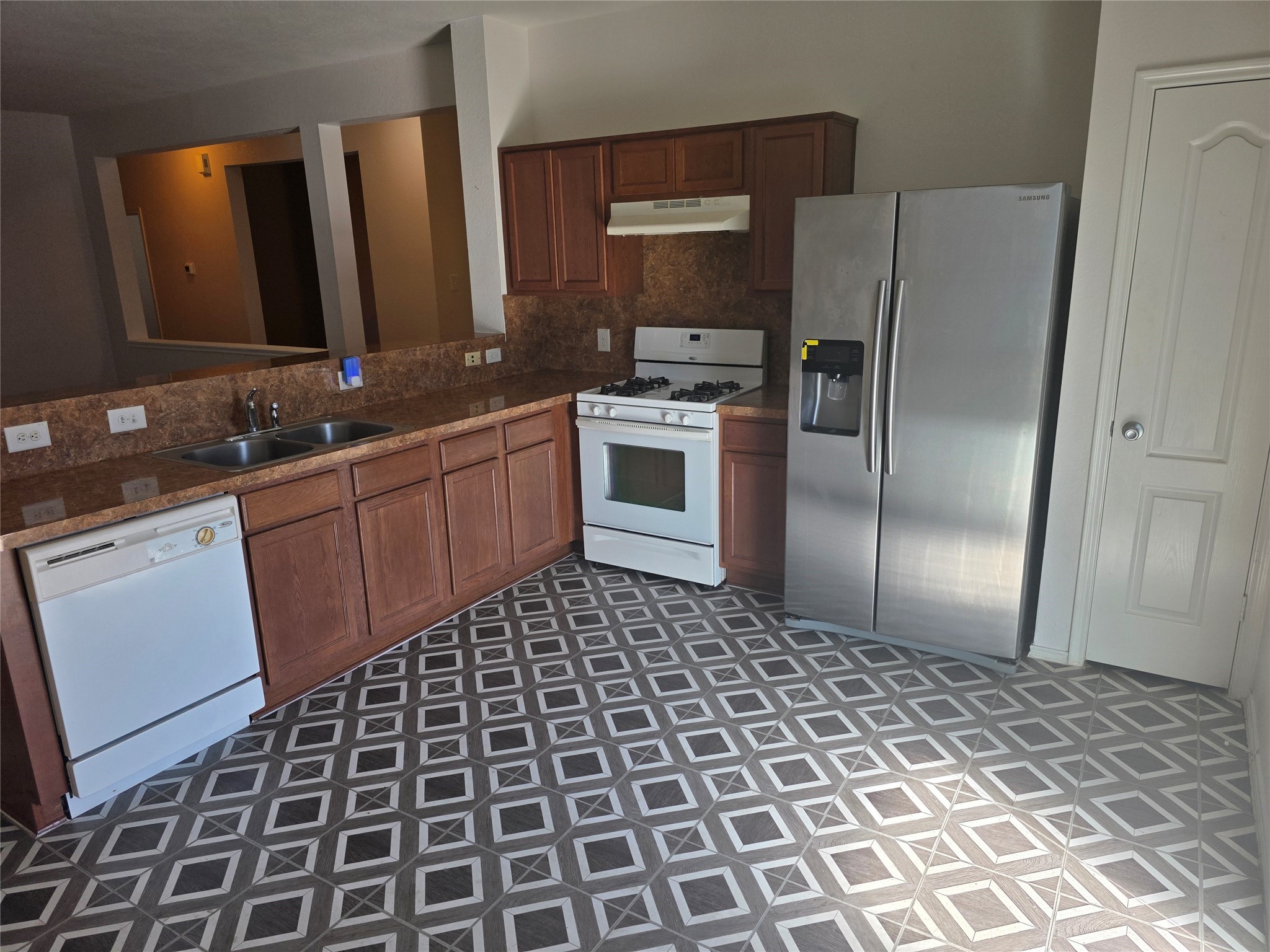 12062 Bach Orchard Trail Houston, TX 77038 - Photo 4 of 20 a kitchen with a sink a stove a refrigerator and cabinets