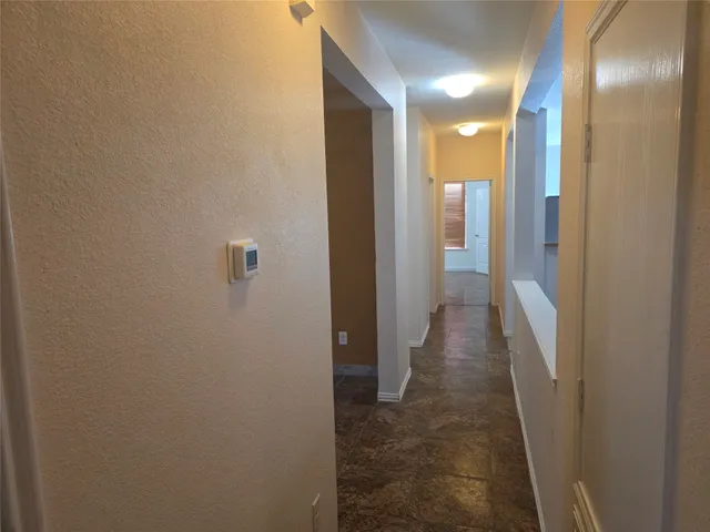 a view of a hallway with wooden cabinets