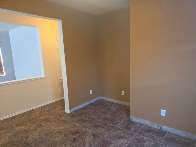 a view of an empty room with windows and entrance