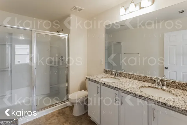 a bathroom with a granite countertop sink mirror and a shower