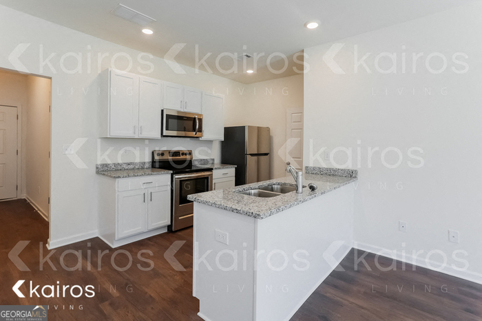 114 Dudley Way Southwest Cartersville, GA 30120 - Photo 3 of 17 a kitchen with granite countertop a refrigerator stove and a sink