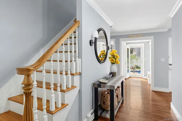 a view of a hallway with wooden floor windows and a kitchen view