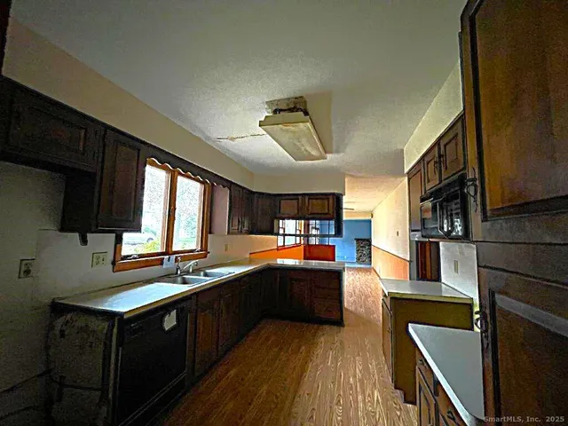 a kitchen with stainless steel appliances sink stove microwave and cabinets