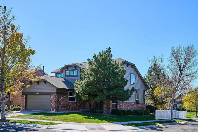 a front view of a house with a yard and palm trees
