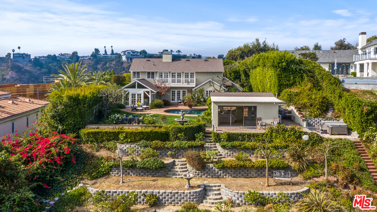 a view of a house with a big yard and large trees