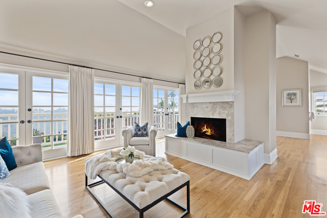 1110 Stradella Road Los Angeles, CA 90077 - Photo 14 of 28 a living room with furniture a fireplace and large window with wooden floor