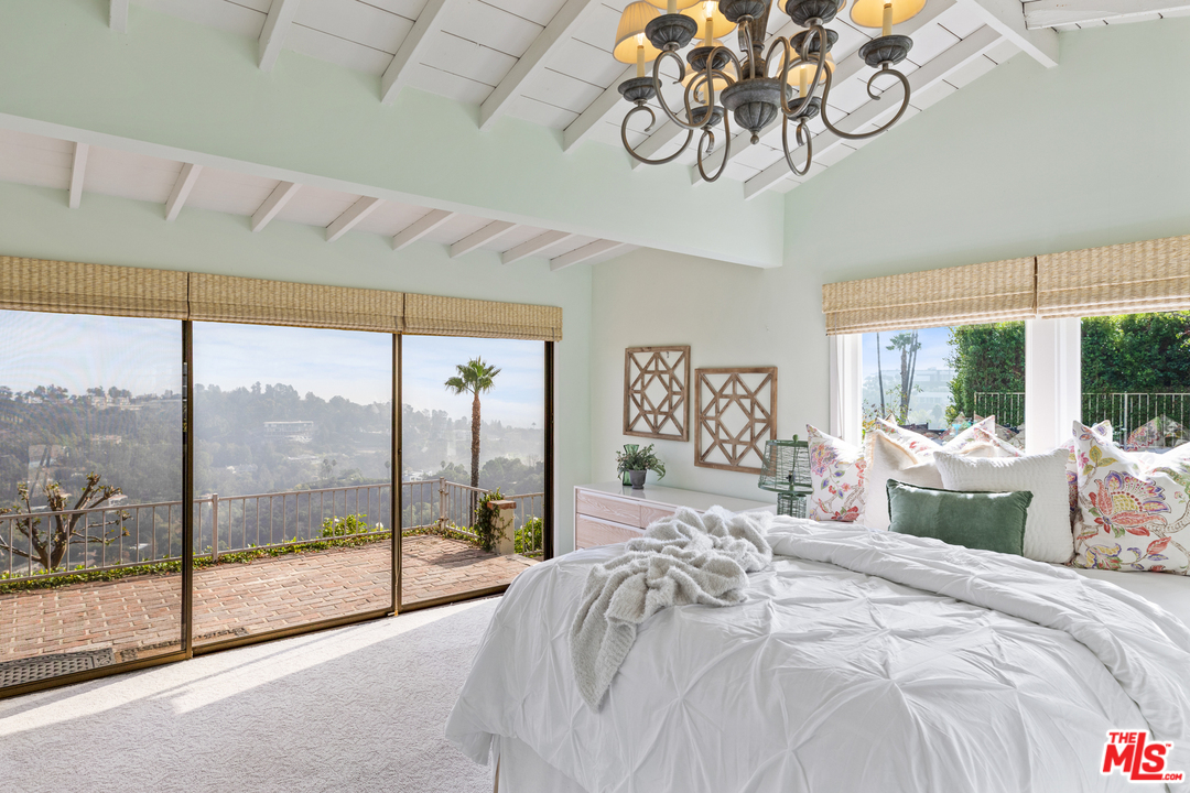 1110 Stradella Road Los Angeles, CA 90077 - Photo 22 of 28 a bedroom with a large bed and a large window with the view of bedroom
