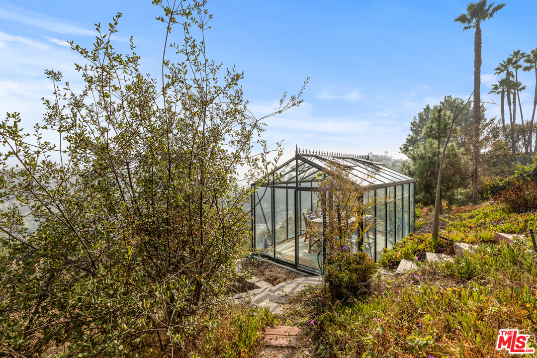 1110 Stradella Road Los Angeles, CA 90077 - Photo 25 of 28 a view of a house with a small yard and plants