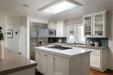 a kitchen with a stove a sink a refrigerator and cabinets