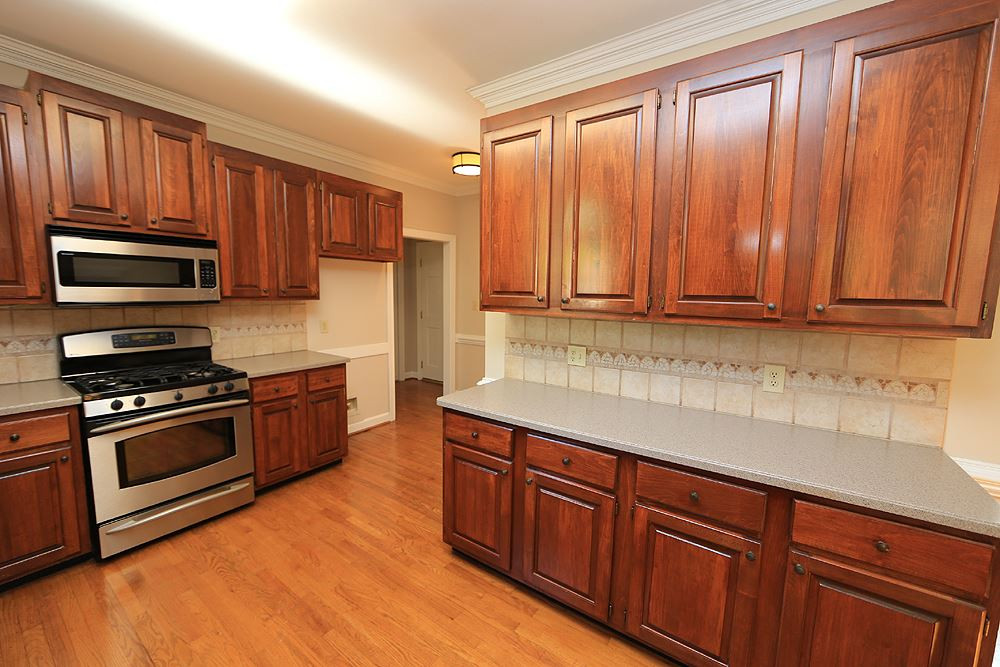 7809 Ketley Court Raleigh, NC 27615 - Photo 9 of 30 Refinished hardwood floors, Stainless Steel appliances, tile back splash and laundry closet around corner as well as 2 closets with shelves. Kitchen