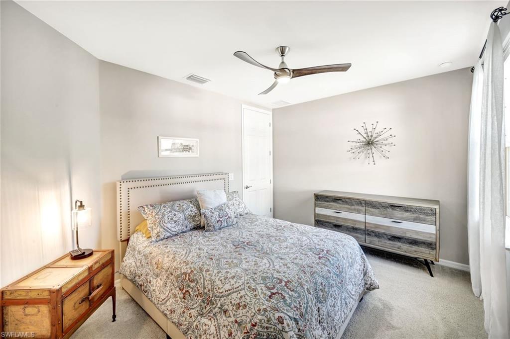 14863 Edgewater Circle Naples, FL 34114 - Photo 14 of 35 a bedroom with a bed and a chandelier