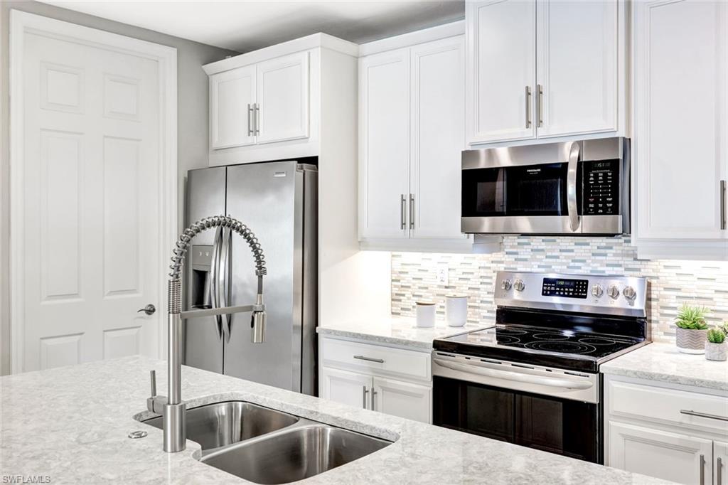 14863 Edgewater Circle Naples, FL 34114 - Photo 2 of 35 a kitchen with stainless steel appliances granite countertop a stove and a microwave