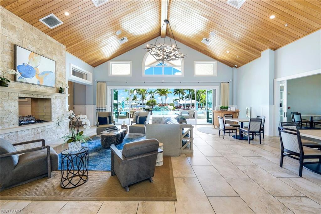 14863 Edgewater Circle Naples, FL 34114 - Photo 34 of 35 a living room with furniture a fireplace and a chandelier
