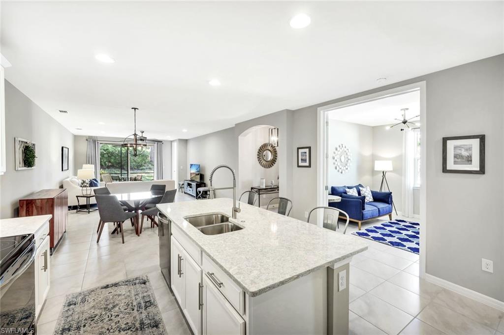 14863 Edgewater Circle Naples, FL 34114 - Photo 5 of 35 a very nice looking dining room with kitchen island a stove a table and chairs
