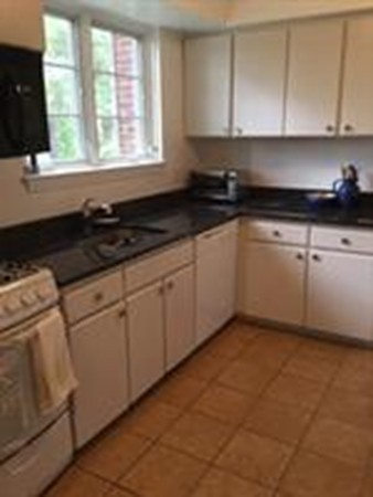 63 Linden Street, Unit 7 Wellesley, MA 02482 - Photo 1 of 11 a white kitchen with granite countertop white cabinets and a granite counter tops