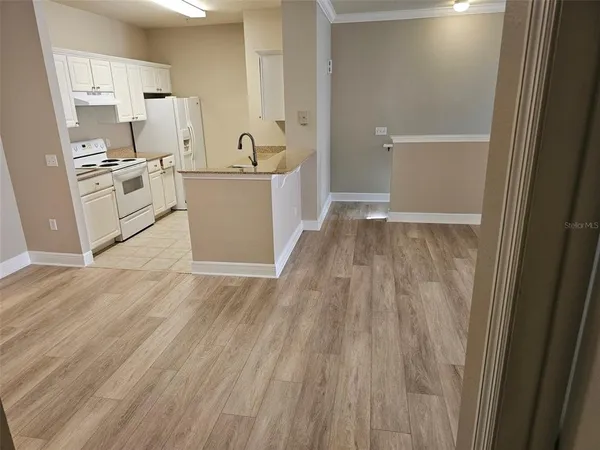 a view of a kitchen with wooden floor and electronic appliances