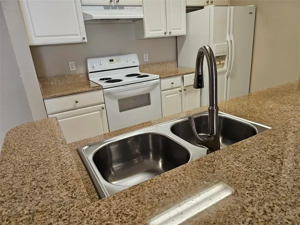 a kitchen with a sink and a stove top oven