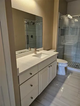 a bathroom with a double vanity sink toilet and shower