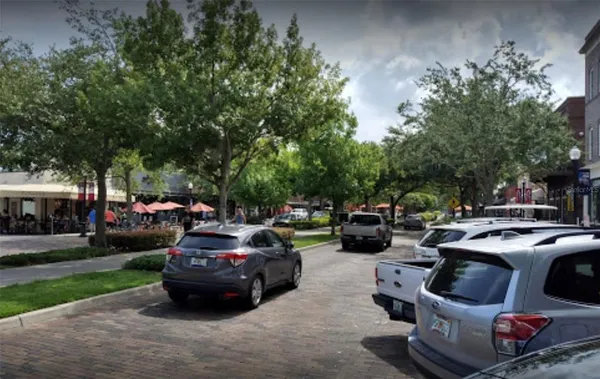 a view of swimming pool with outdoor seating and trees in the background