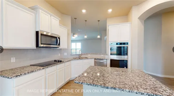 a large kitchen with kitchen island granite countertop a sink and stove top oven