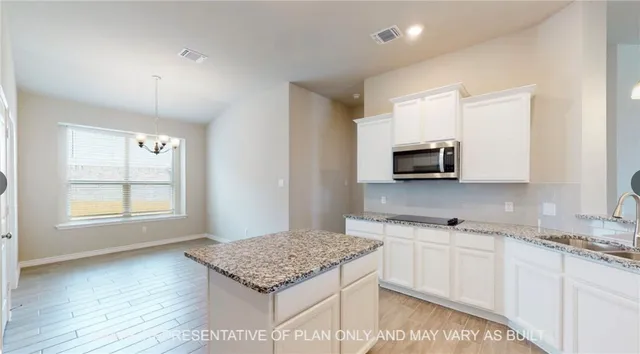 a kitchen with stainless steel appliances granite countertop a stove a sink and a microwave