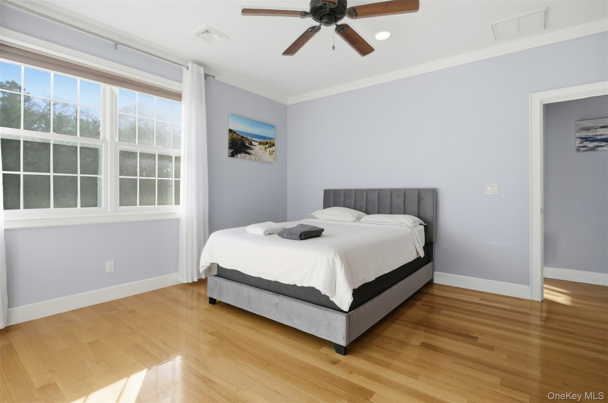 33 A Newtown Road Hampton Bays, NY 11946 - Photo 33 of 50 Bedroom with wood finished floors, ceiling fan, and crown molding