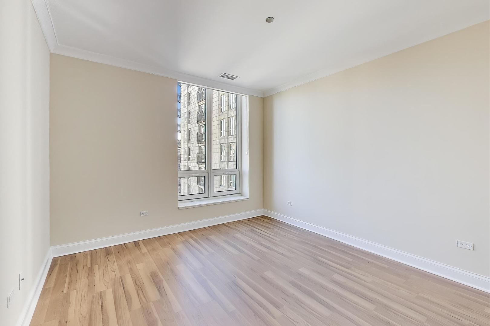 10 East Delaware Place, Unit 20A Chicago, IL 60611 - Photo 12 of 41 an empty room with wooden floor and windows