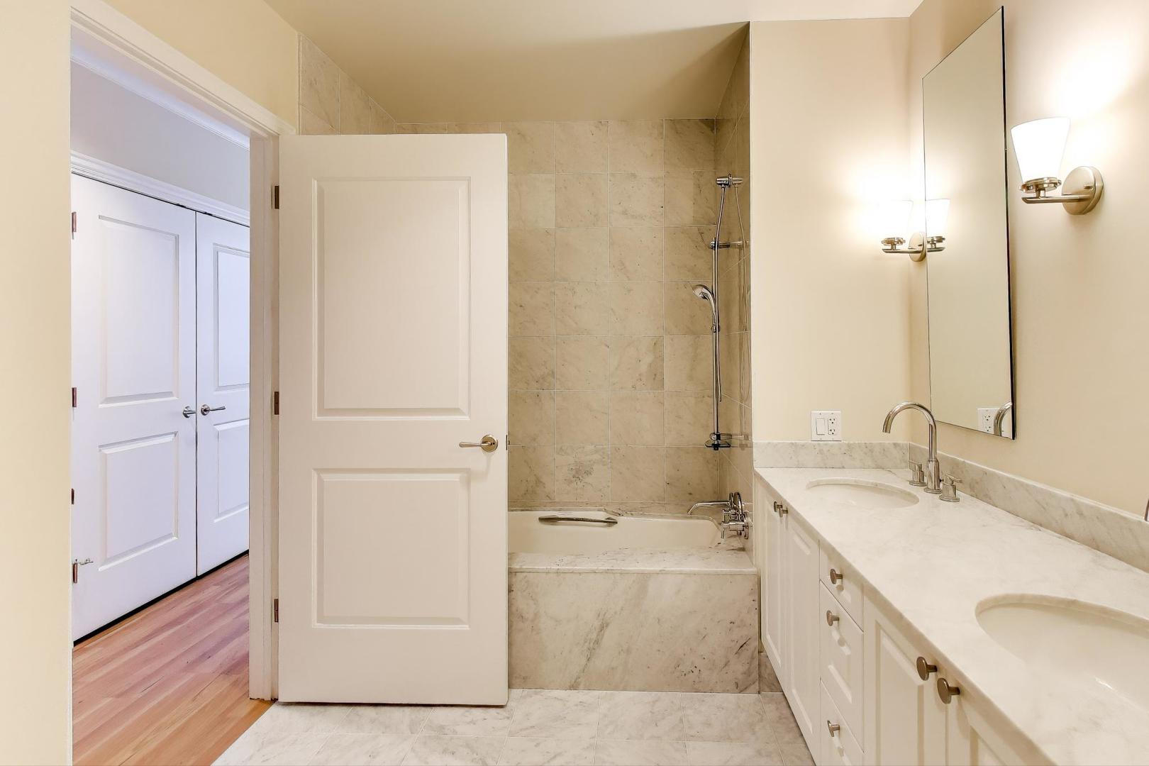 10 East Delaware Place, Unit 20A Chicago, IL 60611 - Photo 15 of 41 a bathroom with a sink a mirror and a bathtub