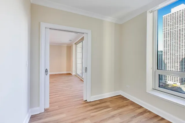 a view of a hallway with wooden floor and a window