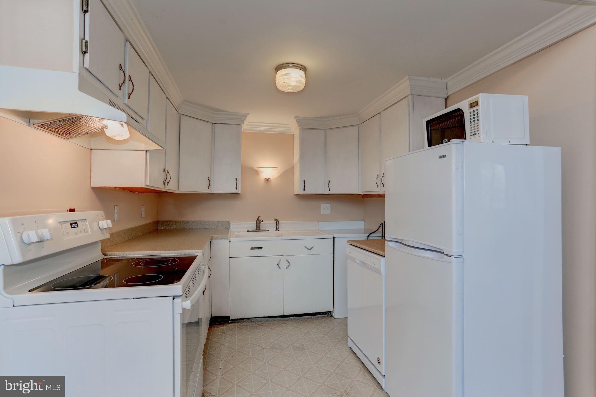 103 Club House Road Front Royal, VA 22630 - Photo 8 of 30 a kitchen with a sink a refrigerator and white cabinets