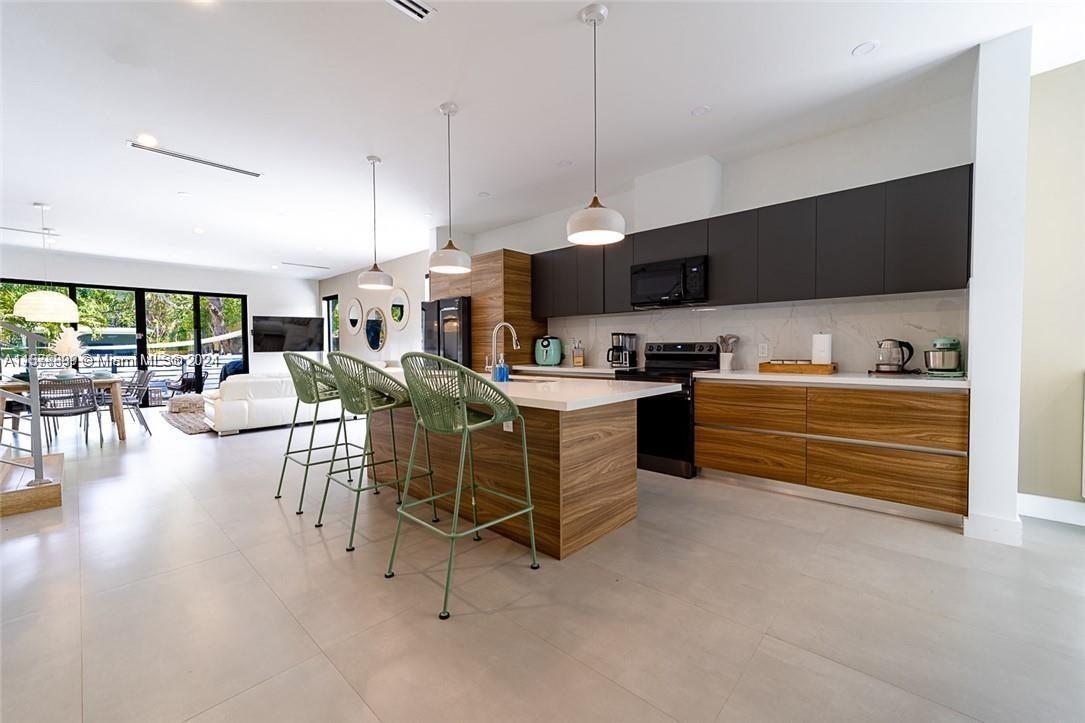 a kitchen with stainless steel appliances kitchen island granite countertop a table and chairs in it