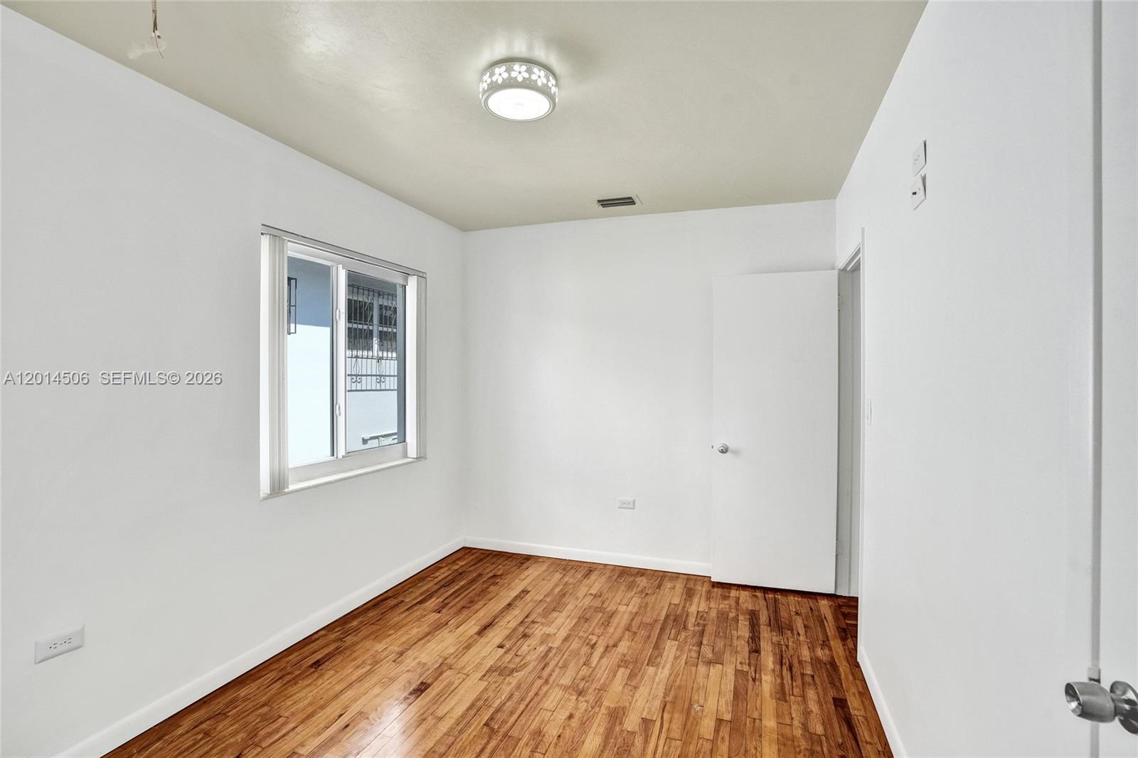 2420 Southwest 16th Street Miami, FL 33145 - Photo 25 of 35 an empty room with wooden floor and windows