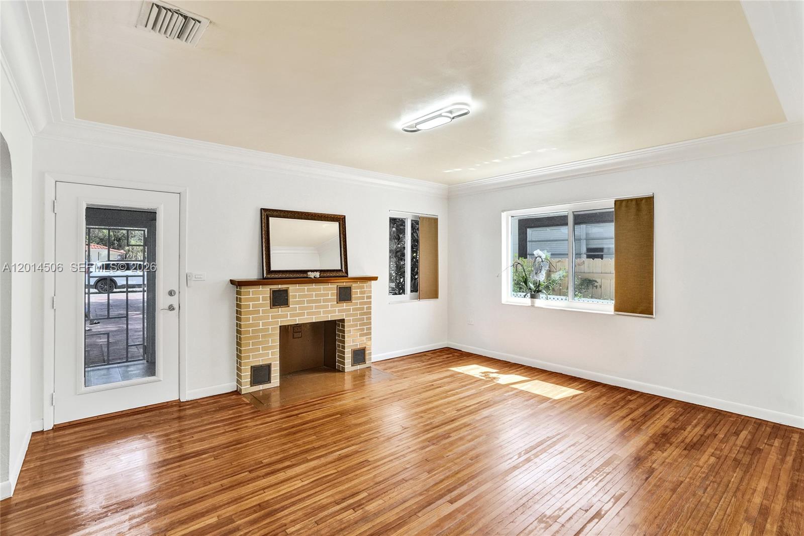 2420 Southwest 16th Street Miami, FL 33145 - Photo 3 of 35 a view of a livingroom with a fireplace wooden floor and window