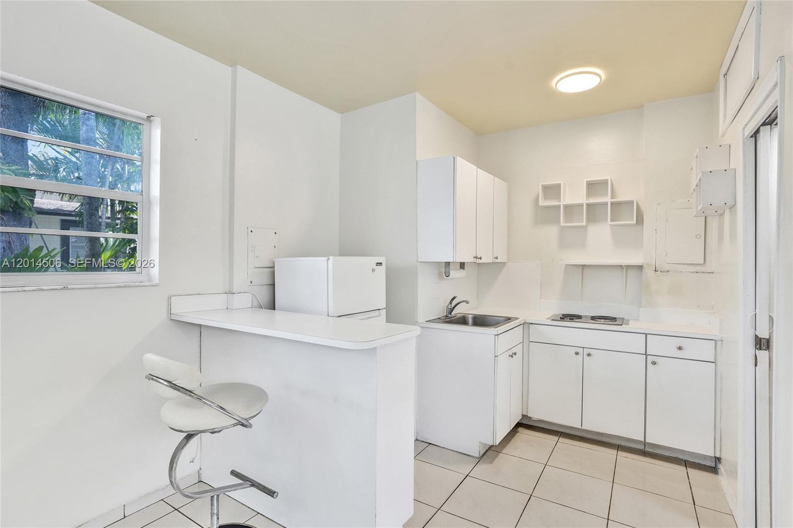 2420 Southwest 16th Street Miami, FL 33145 - Photo 33 of 35 a kitchen with a sink window and cabinets