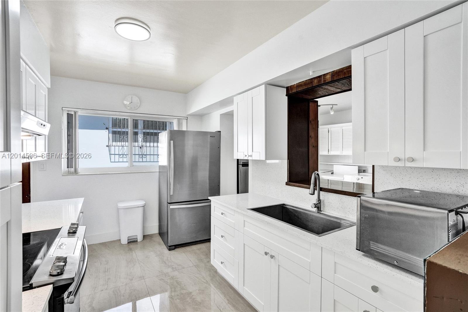 2420 Southwest 16th Street Miami, FL 33145 - Photo 10 of 35 a kitchen with a sink a refrigerator and cabinets