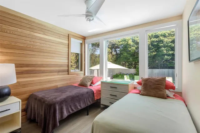 a bedroom with two beds and a large window