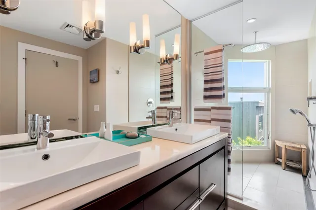 a bathroom with a double vanity sink a mirror and a bathtub