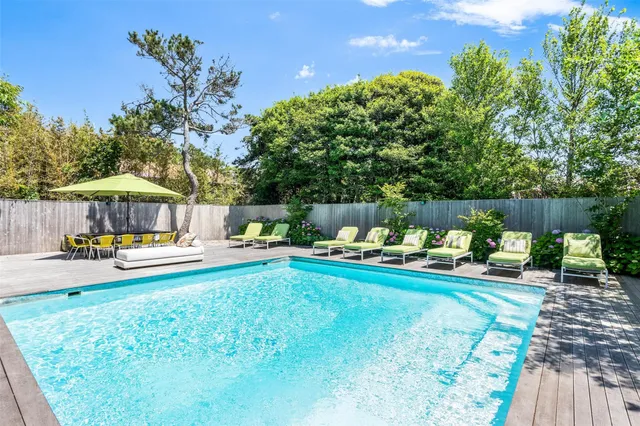 a view of a house with swimming pool and sitting area