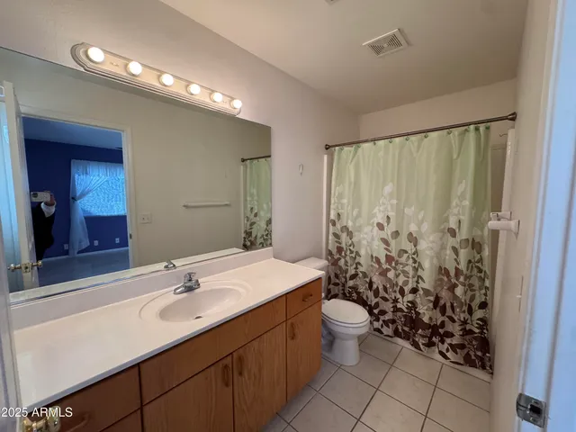 a view of an empty room with window and chandelier fan