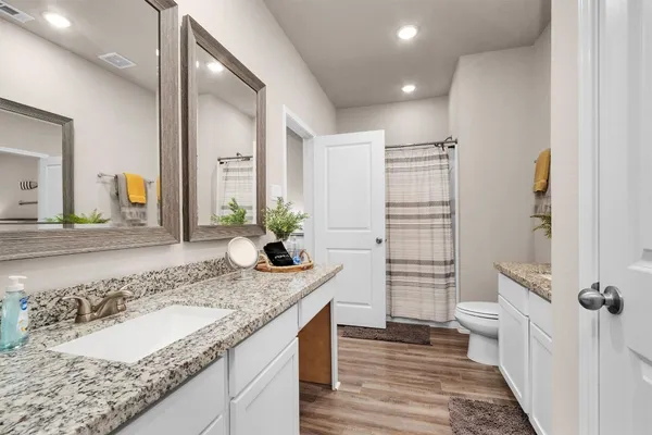 a bathroom with a granite countertop sink and a mirror