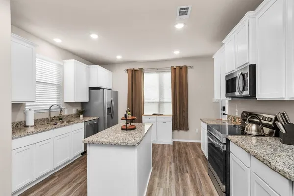 a kitchen with a sink stove top oven and refrigerator