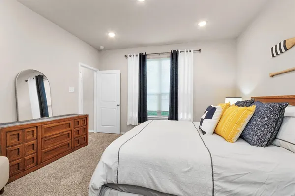 a bedroom with a large bed and a dresser